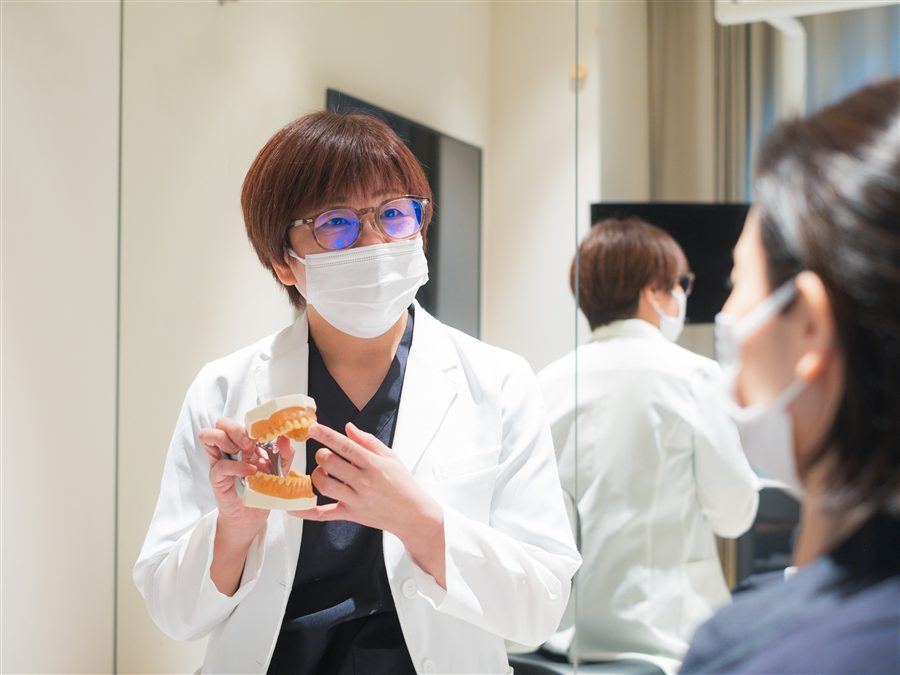 スタッフが歯の模型を使ってケア方法を説明する様子
