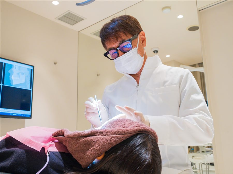 院長が装置を調整しながら治療を行う様子